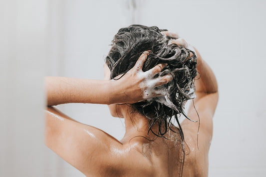 Girl washing hair with GK Hair shampoo